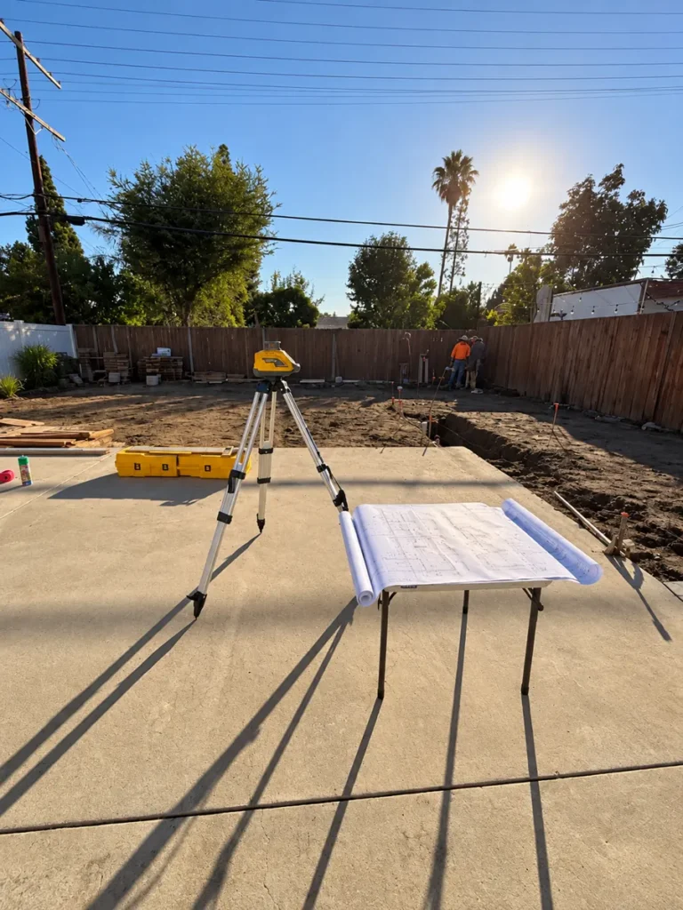 Laser level and plans on site during layout of the Encino ADU