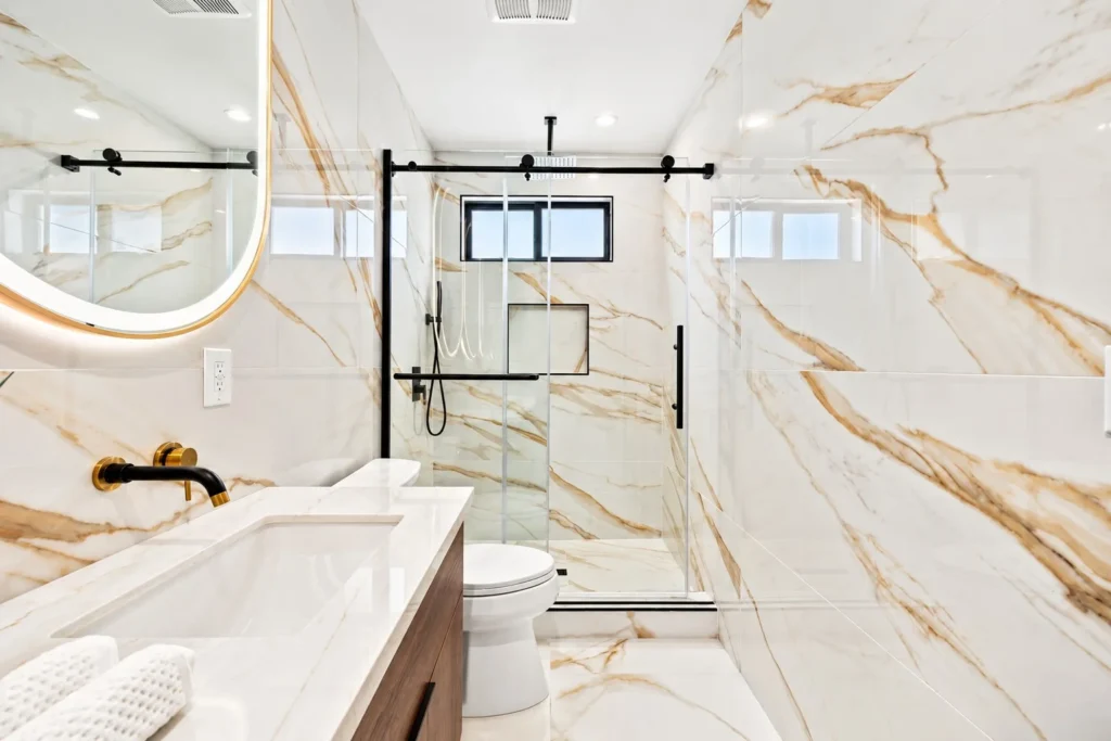 Bathroom in a MAMOS remodel in Rancho Park, marble-look tile and a glass shower slider