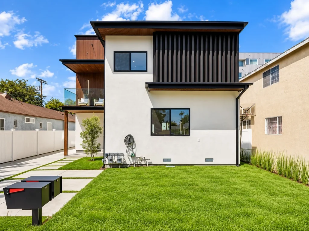 Rancho Park home after a MAMOS remodel, white stucco with wood siding and a glass balcony